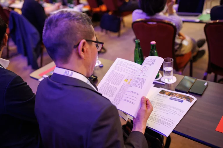 Delegate reading the IFBF Book of Papers at the conference