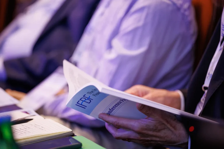 Delegate leafing through the IFBF Book of Papers during a session